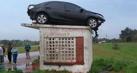 Un Toyota Corolla choca, vuelca y queda en el techo de una parada de transporte público
